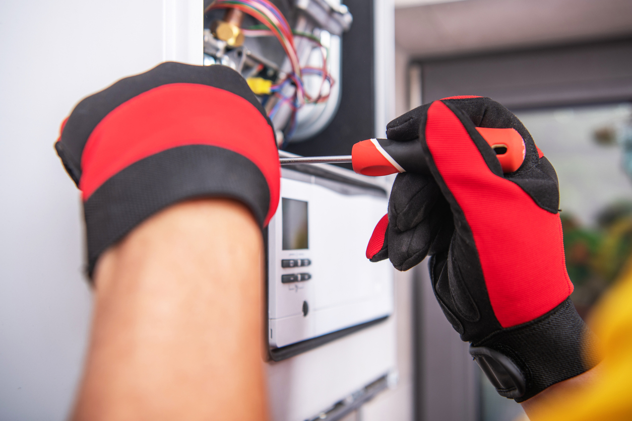 Hands of an HVAC technician repairing a home's heating system