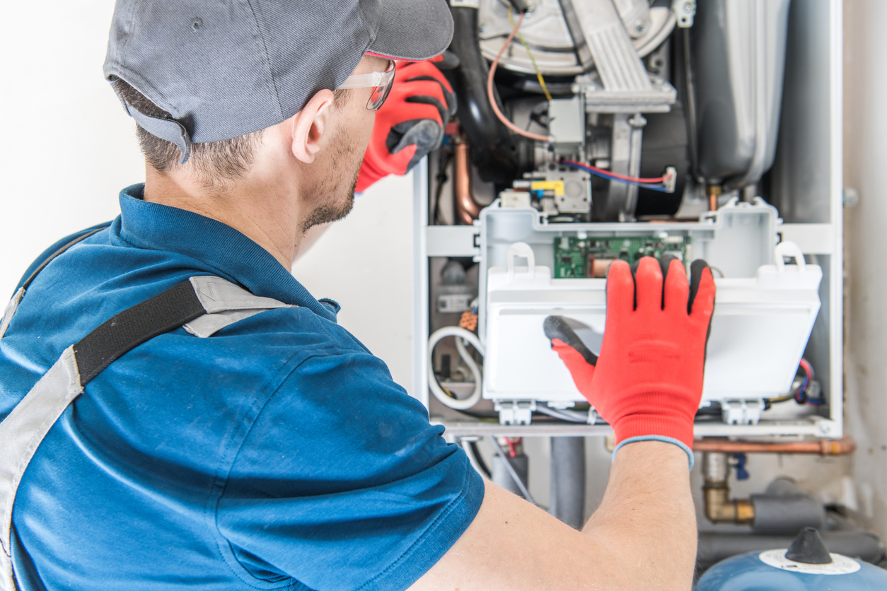 HVAC technician installing a new gas heating unit in a home