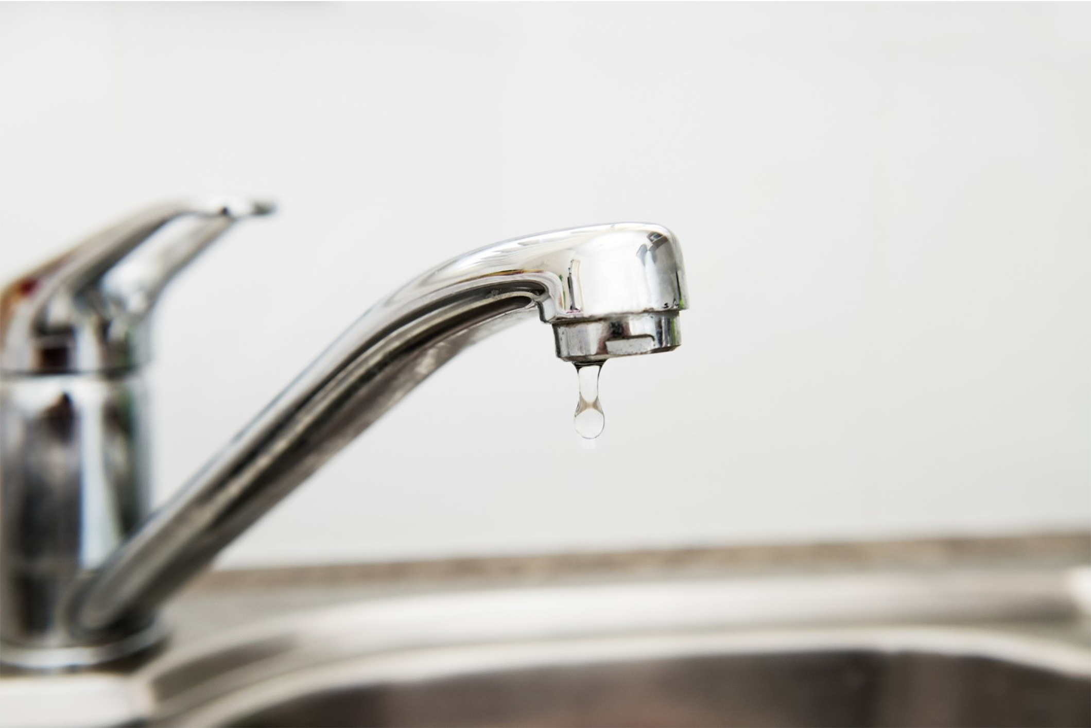 Sink faucet with a drip about to fall off